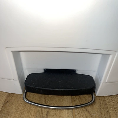 black plastic foot pedal of a white dustbin