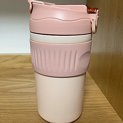 a pink travel mug with a pink silicon sleeve on it